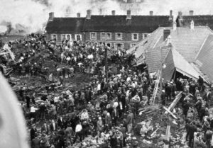 photo of the masses of rescue workers forming coherent lines of clearance of the debris. Note how far up the building the slurry covered. these workers and villagers stand in line with the roof of the school