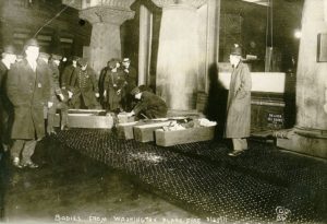 Bodies of the victims being placed in coffins on the sidewalk Photo Credit- This image is available from the United States Library of Congress